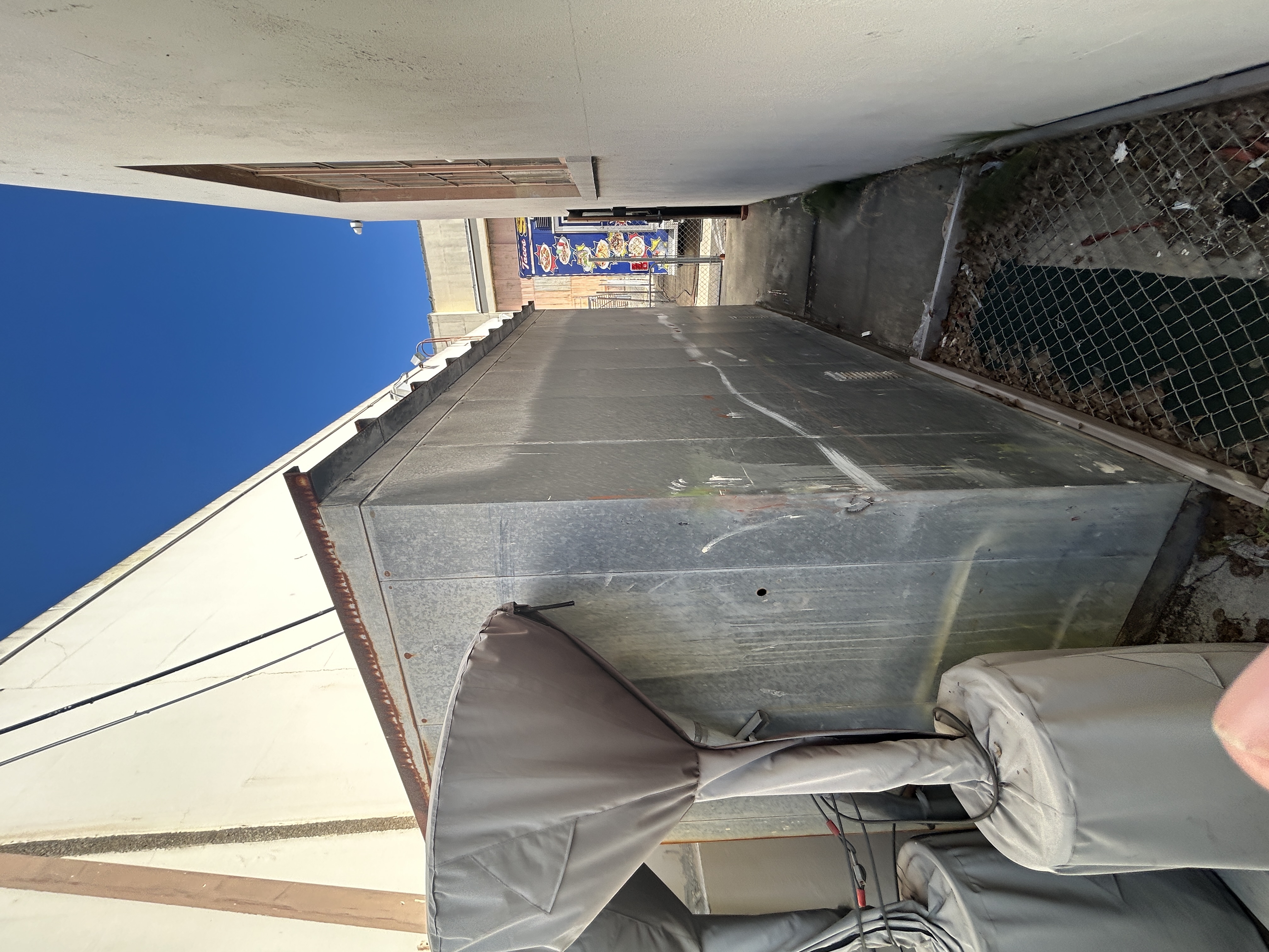 Two covered outdoor propane heaters leaning against a metal shed