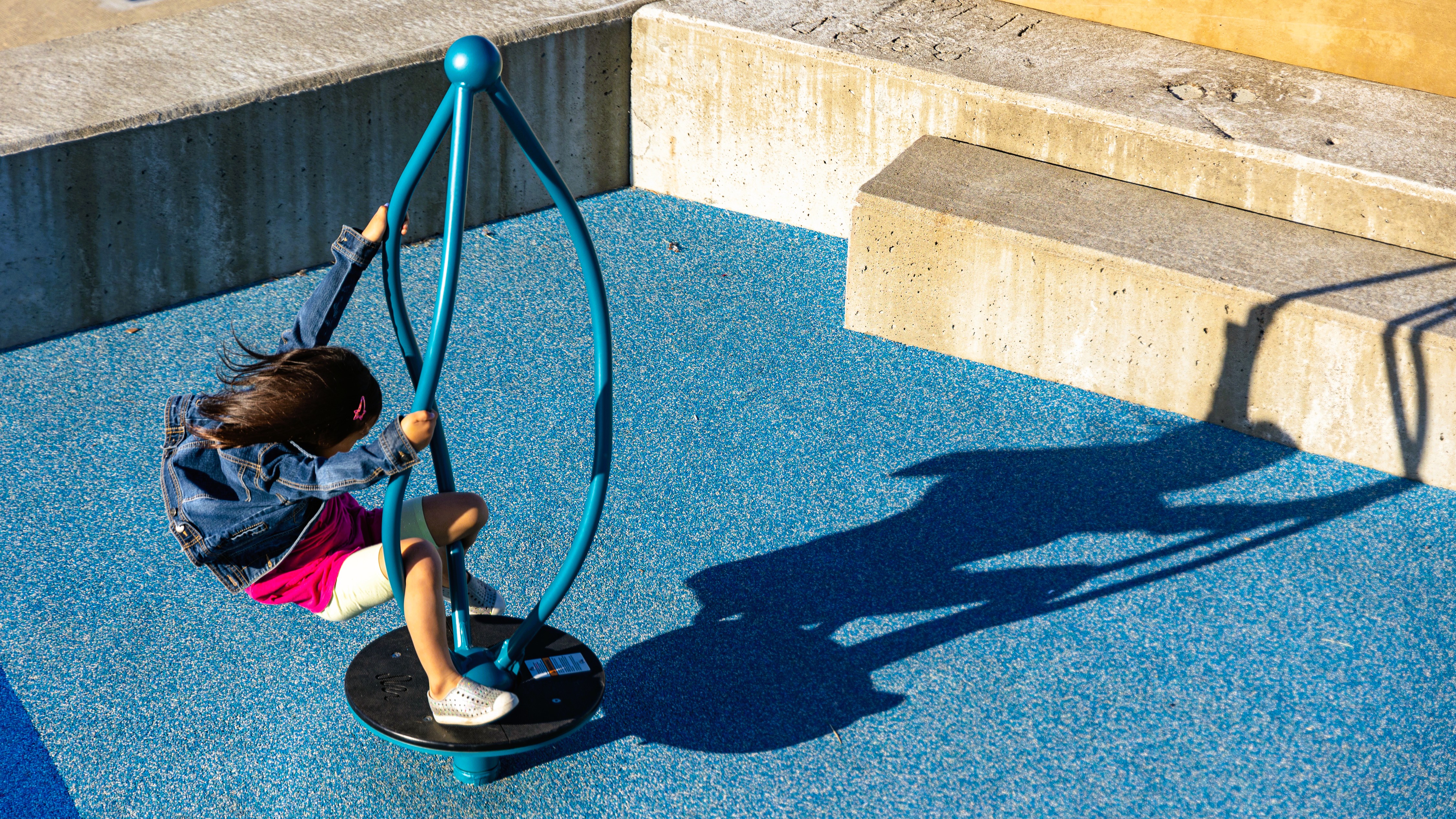 Little kid have a great time on the playground at the park on a sunny day! 